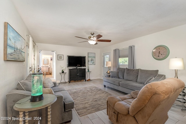 living room with ceiling fan and light hardwood / wood-style flooring