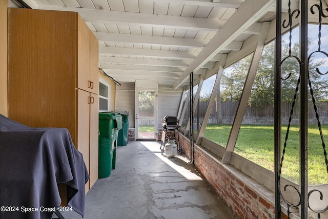 unfurnished sunroom with beam ceiling and wooden ceiling