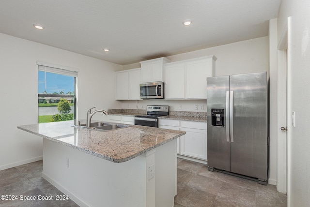 kitchen with a kitchen island with sink, sink, white cabinetry, and stainless steel appliances