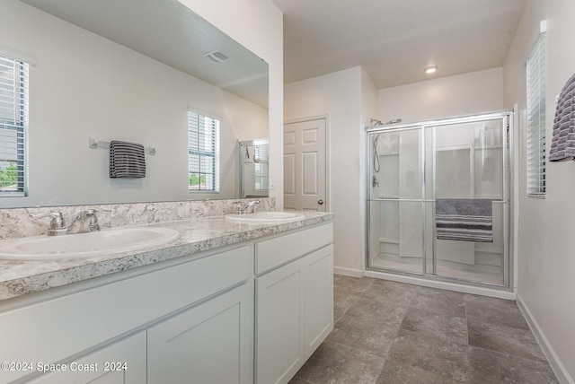 bathroom with a shower with door and vanity