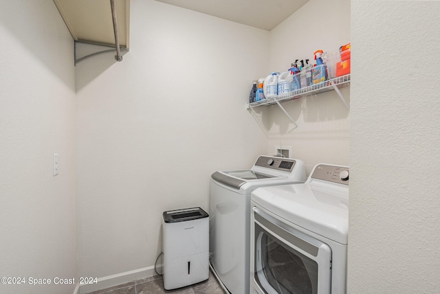 laundry room with washer and clothes dryer and light tile patterned flooring