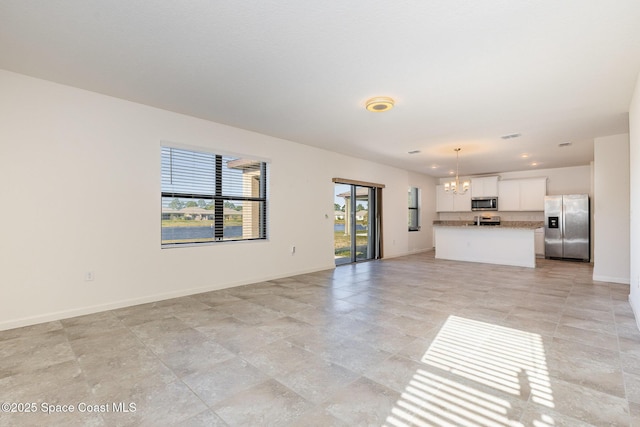 unfurnished living room with a notable chandelier