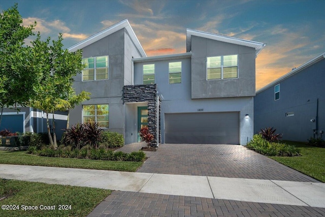 14119 SW Safi Ter, Port St Lucie, FL 34987 - contemporary house featuring an attached garage, stucco siding, and decorative driveway