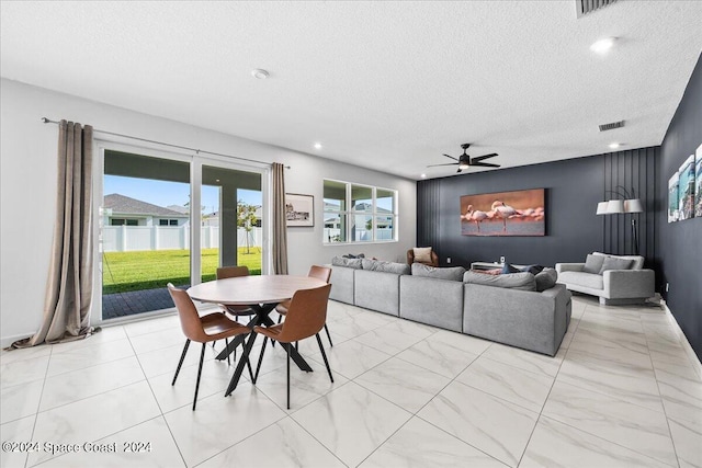 living room featuring a textured ceiling and ceiling fan