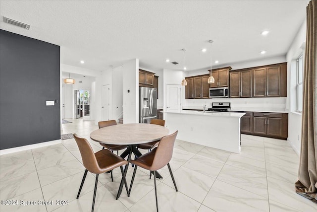 dining space featuring a textured ceiling and sink