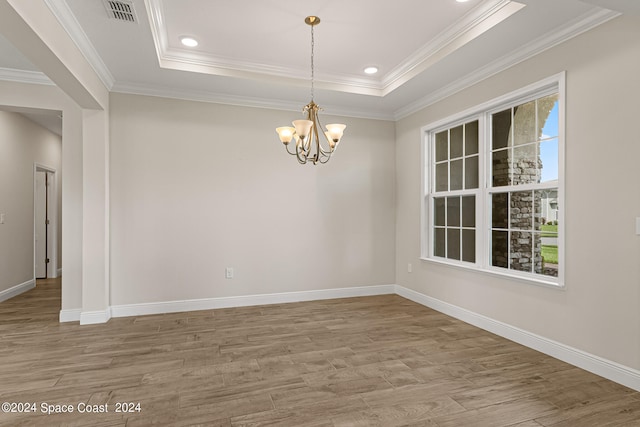 unfurnished room featuring ornamental molding, a chandelier, and hardwood / wood-style flooring