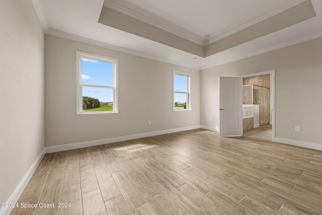 unfurnished room with light wood-type flooring, a healthy amount of sunlight, and ornamental molding