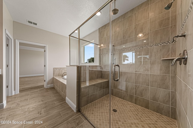 bathroom with separate shower and tub and a textured ceiling