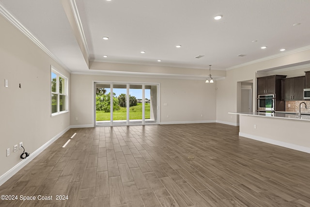 unfurnished living room with ornamental molding, hardwood / wood-style flooring, and sink