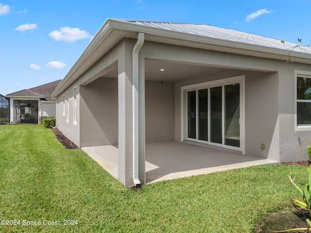 back of property with a yard and a patio area