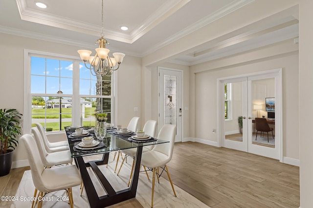 dining area featuring light hardwood / wood-style flooring, a notable chandelier, and crown molding