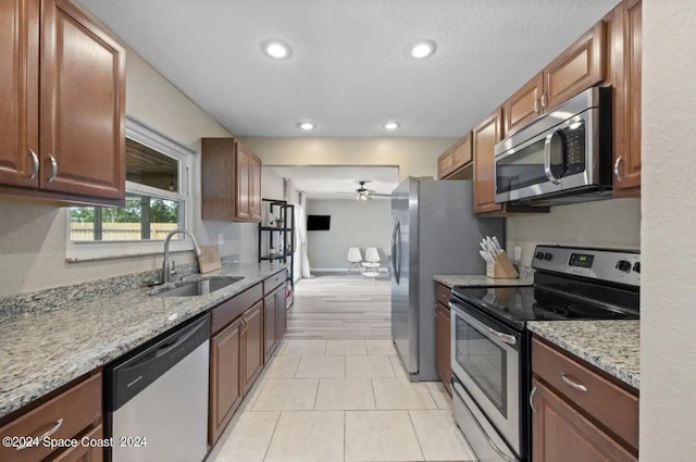 902 Beaverdale Ln, Rockledge, FL 32955 - kitchen with recessed lighting, light stone counters, stainless steel appliances, a sink, and a ceiling fan