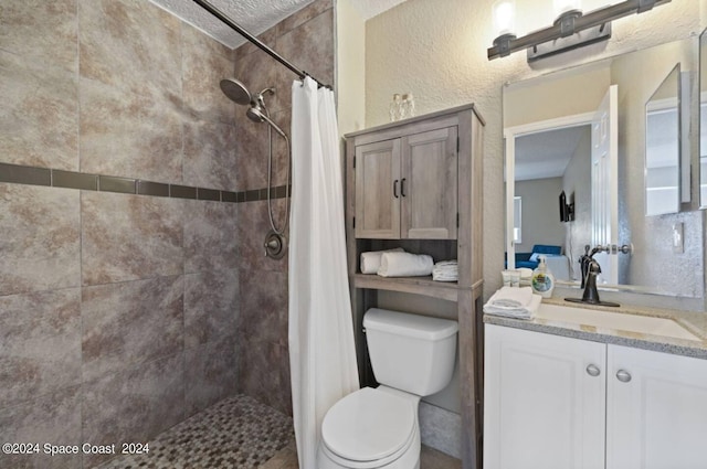 bathroom featuring toilet, vanity, a shower with curtain, and a textured ceiling