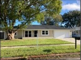 single story home with a front yard and a garage