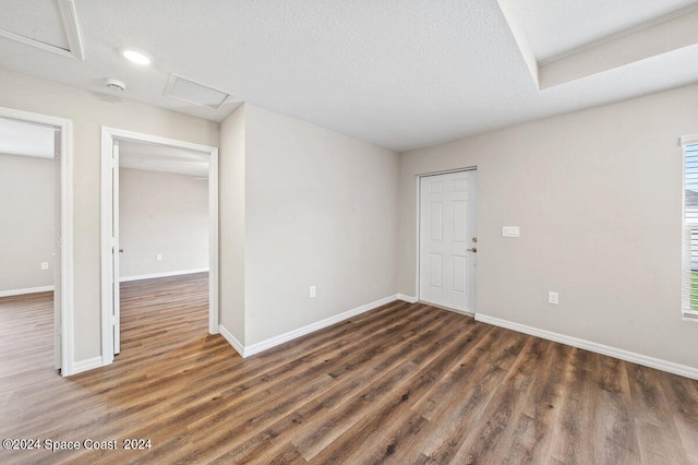 unfurnished room with a textured ceiling, dark hardwood / wood-style floors, and a healthy amount of sunlight