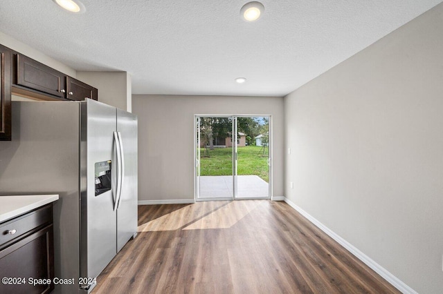 kitchen featuring dark brown cabinets, dark hardwood / wood-style flooring, stainless steel fridge with ice dispenser, and a textured ceiling