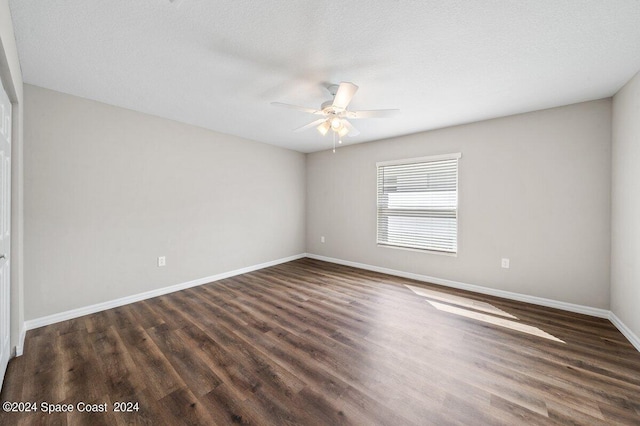 spare room featuring a textured ceiling, ceiling fan, and dark wood-type flooring