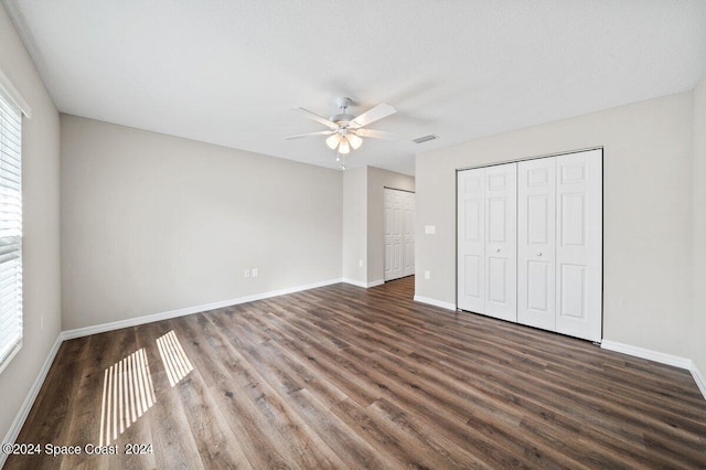 unfurnished bedroom with ceiling fan, dark hardwood / wood-style flooring, and a textured ceiling