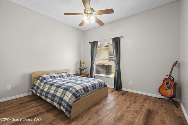 bedroom with dark hardwood / wood-style flooring, a textured ceiling, and ceiling fan