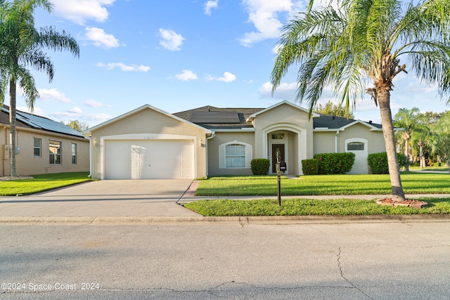 single story home featuring a garage and a front yard