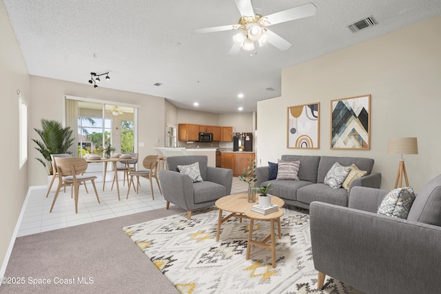 carpeted living room with ceiling fan and a textured ceiling