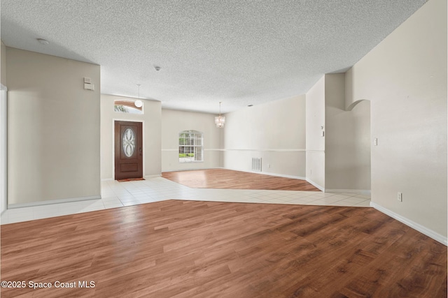 foyer entrance featuring a textured ceiling and light wood-type flooring