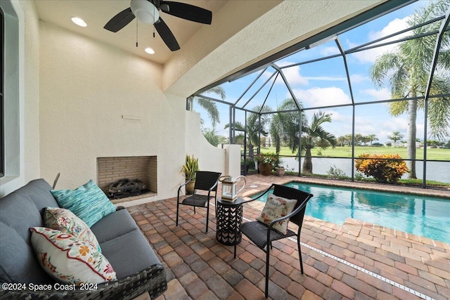 view of pool featuring ceiling fan, a water view, a lanai, and a patio area