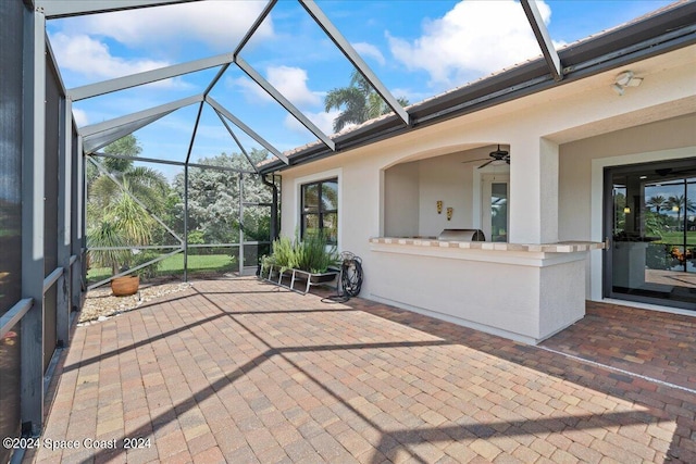 view of patio / terrace featuring glass enclosure and ceiling fan