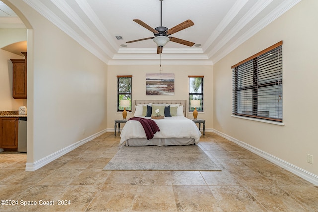 bedroom featuring a tray ceiling, ornamental molding, and ceiling fan