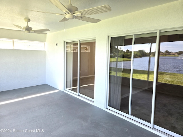 unfurnished sunroom with a water view, ceiling fan, and a healthy amount of sunlight