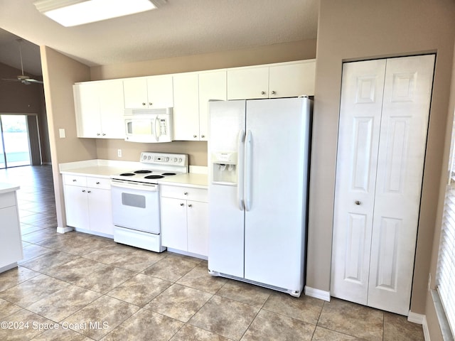 kitchen with white cabinetry, a textured ceiling, light tile patterned floors, and white appliances