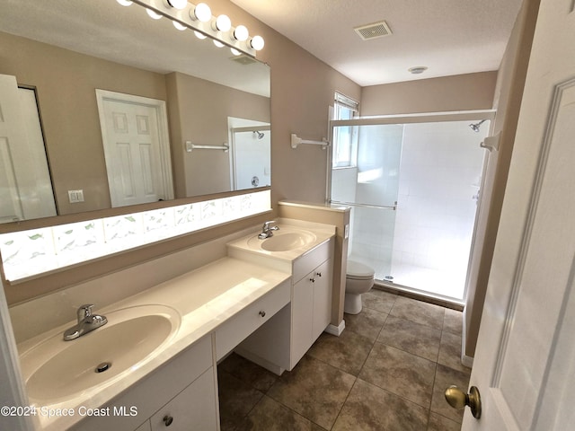 bathroom with a textured ceiling, an enclosed shower, toilet, tile patterned floors, and vanity