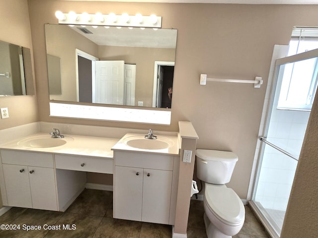 bathroom with toilet, vanity, and tile patterned floors