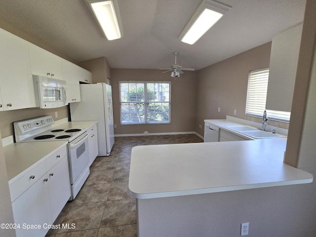 kitchen with a wealth of natural light, kitchen peninsula, and white appliances