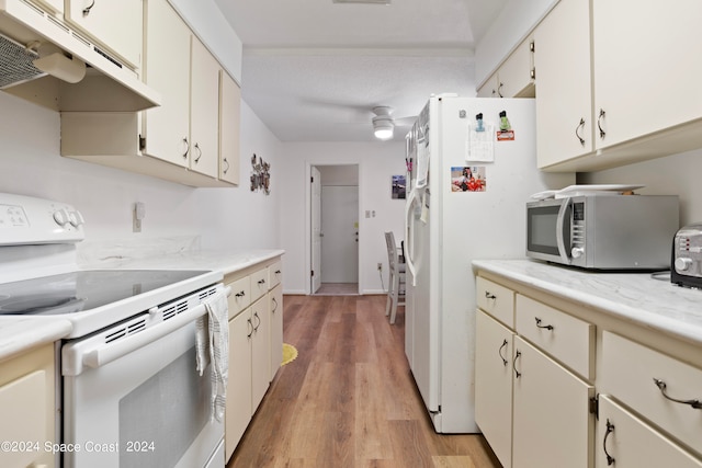 kitchen featuring light hardwood / wood-style flooring, white appliances, and cream cabinets