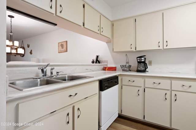 kitchen featuring dishwasher, hanging light fixtures, dark wood-type flooring, and sink