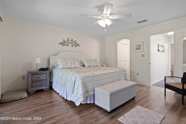 bedroom with ceiling fan, a closet, and dark hardwood / wood-style flooring