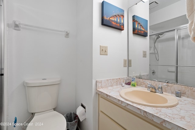 bathroom with walk in shower, vanity, and toilet