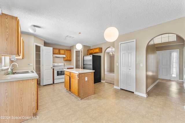 kitchen featuring a kitchen island, hanging light fixtures, stainless steel fridge, white electric range oven, and a textured ceiling