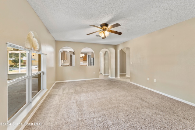 carpeted spare room featuring ceiling fan and a textured ceiling