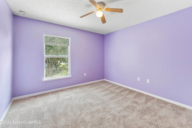 carpeted empty room with ceiling fan and a textured ceiling