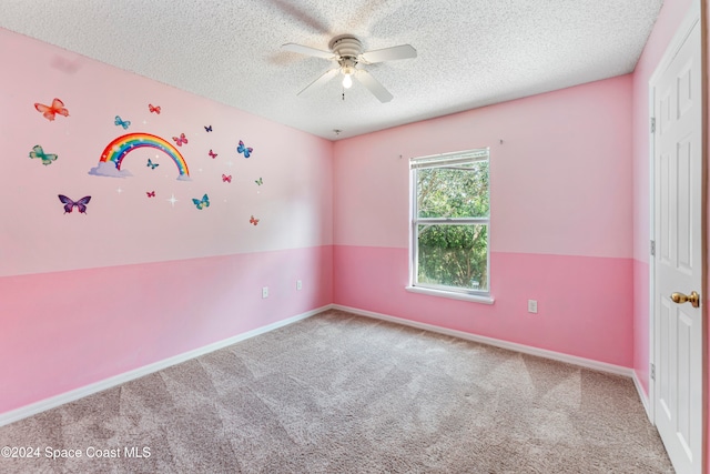 empty room featuring a textured ceiling, carpet, and ceiling fan