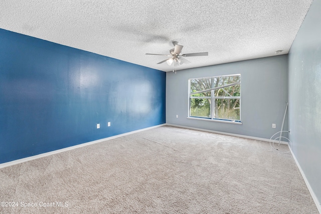 empty room with ceiling fan, carpet flooring, and a textured ceiling