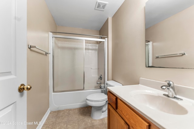 full bathroom featuring vanity, toilet, shower / bath combination with glass door, and tile patterned flooring