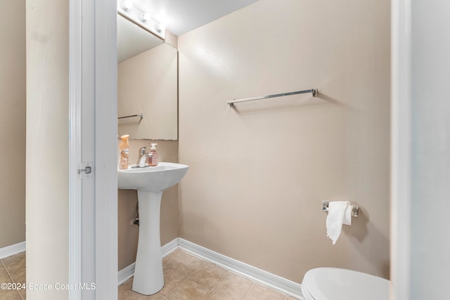 bathroom featuring toilet and tile patterned flooring