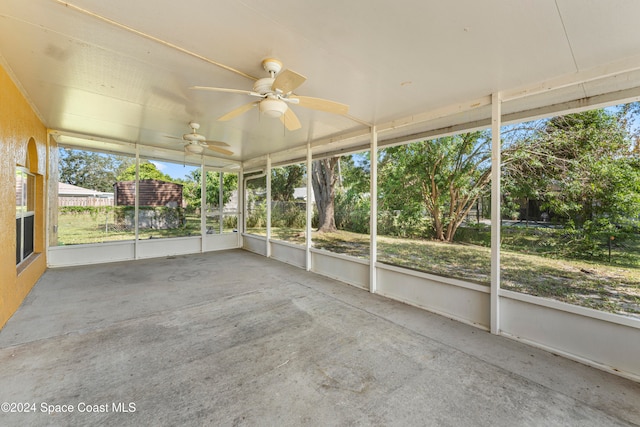 unfurnished sunroom with ceiling fan