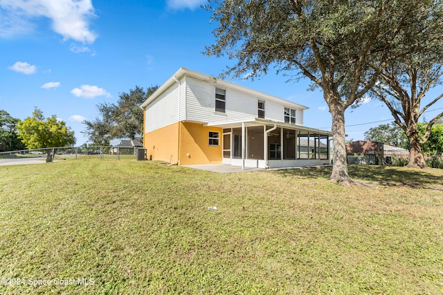 back of house featuring a lawn and a sunroom