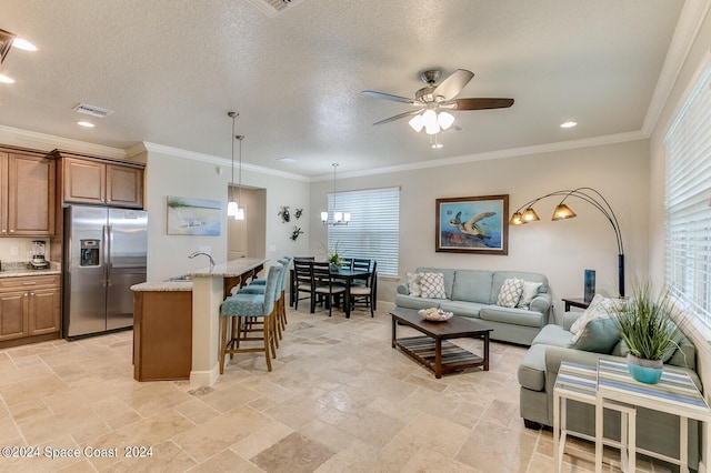 living area with ceiling fan with notable chandelier, visible vents, recessed lighting, and stone tile flooring