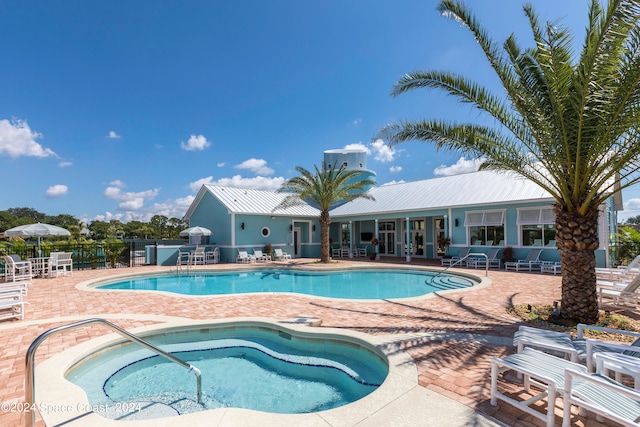 view of swimming pool featuring a patio and a hot tub