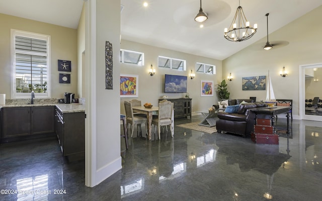 living room featuring high vaulted ceiling, baseboards, a chandelier, and visible vents